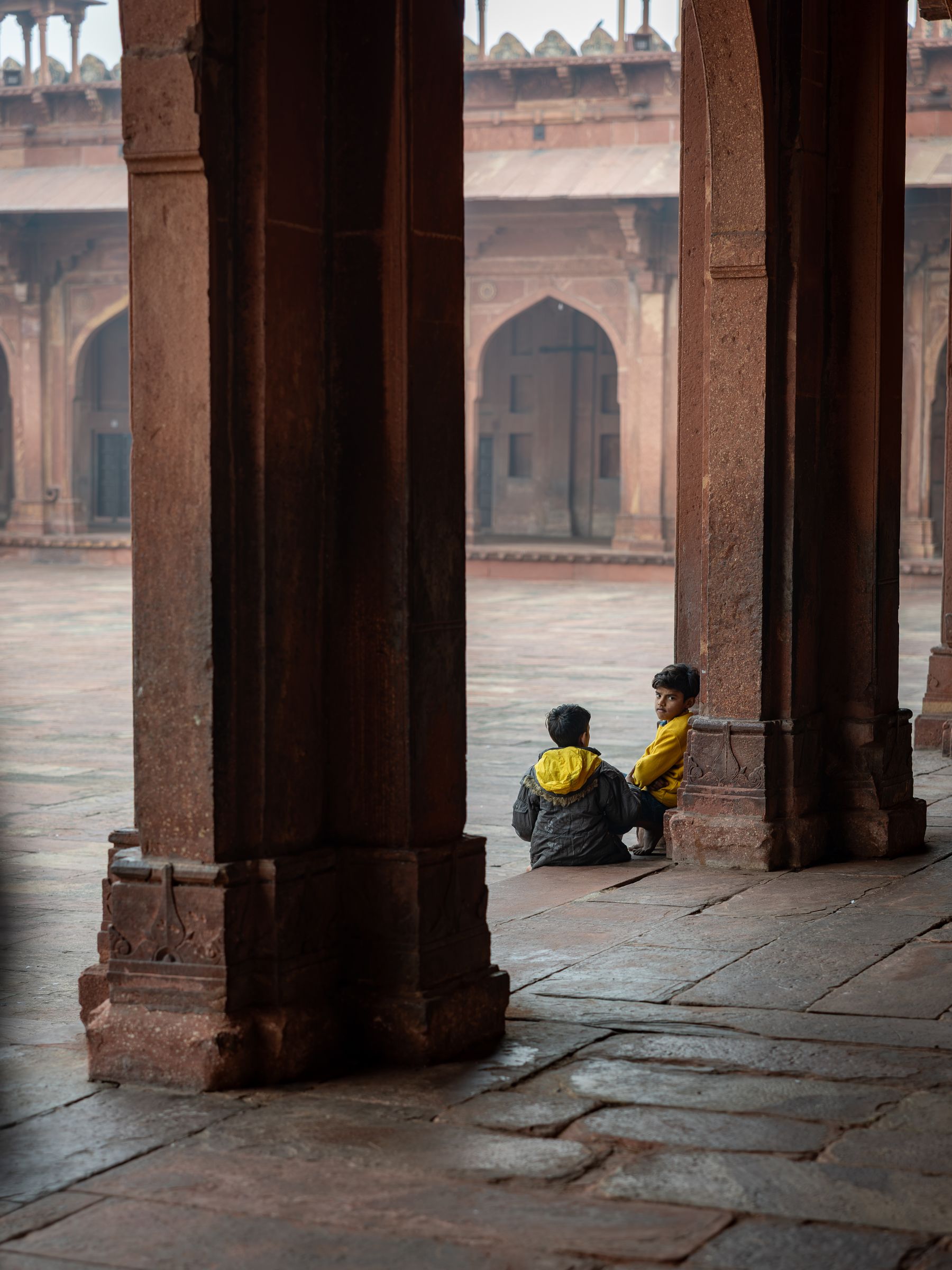 Seated Boys In Red Sandstone Courtyard